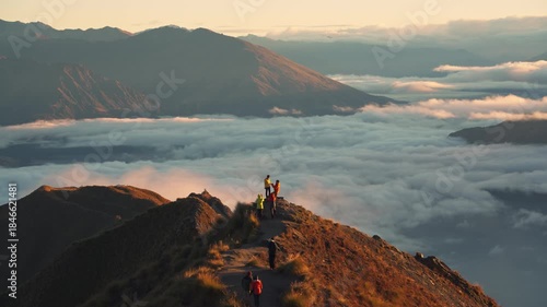 Couple proposing marriage on Roys Peak above foggy mountain at sunrise