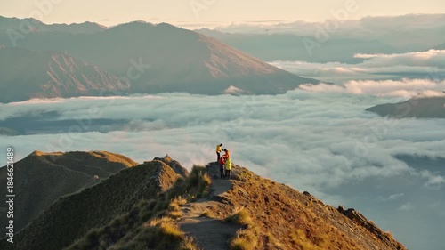 Couple proposing marriage on Roys Peak above foggy mountain at sunrise