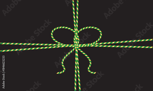Green and gold String Rope with Crossed Bow Isolated on black background. symbolizing gift wrapping, holidays, celebration, and handmade packaging on black  background.