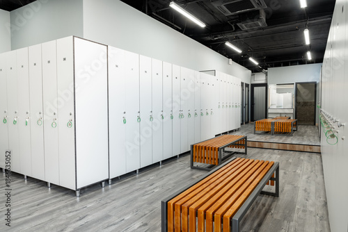 Modern gym locker room area with benches and secure lockers for personal belongings