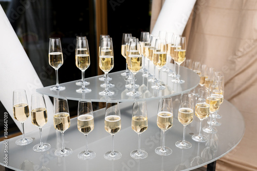 Elegant multi-tier arrangement of champagne flutes filled with sparkling wine