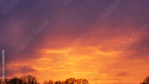 Beautiful sunset sky with vibrant orange glow and purple clouds