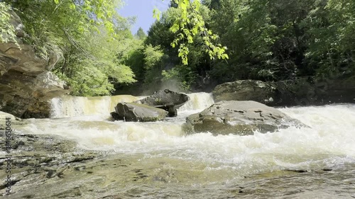 Raging water runoff after a massive storm shows Potter’s Falls in Tennessee moving a large volume of dirty water down the Obed River.