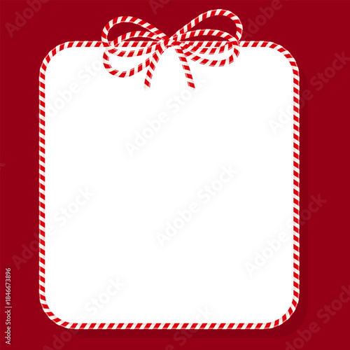 A square white Christmas frame on a red background. An empty text area with a gift tied with red cotton twine and ribbons is perfect for New Year's or holiday packaging.