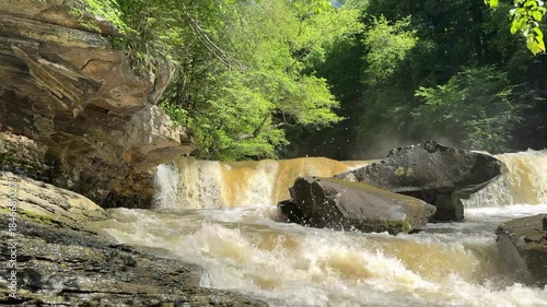 Raging water runoff after a massive storm shows Potter’s Falls in Tennessee moving a large volume of dirty water down the Obed River.