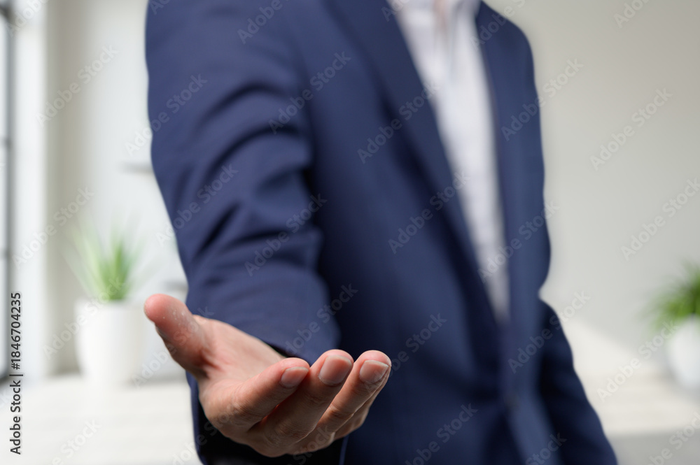 Obraz premium Businessman Offering Hand for Deal or Assistance in Modern Office