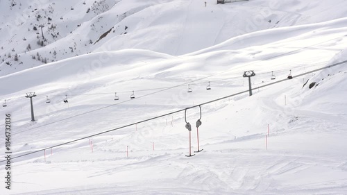 Empty surface ski lift operating on snowy mountain