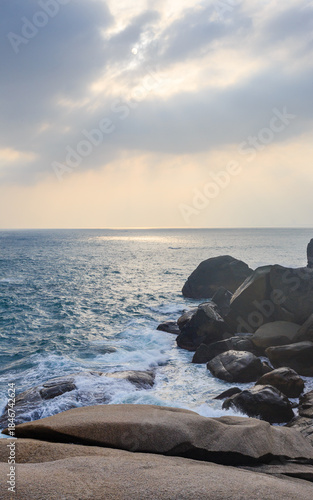 The scenery of Stone Park in Hainan, China, features emerald-green seawater crashing against the rocks, creating beautiful waves.