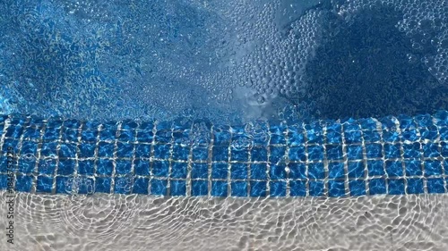 Vivid, fast-moving pool water with energetic bubbling and shifting reflection