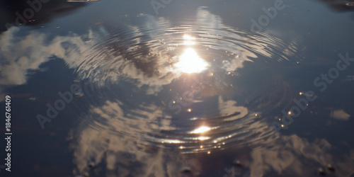 Water reflects sun and clouds during a calm day at a natural setting