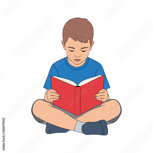 A boy sits cross-legged, engrossed in a red book, wearing blue shirt and shorts