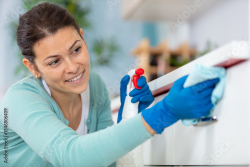 Photos concentrated woman scrubbing the bar in kitchen