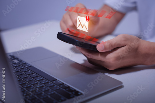 Valokuva person typing on laptop receives scam notification, illustrating cybersecurity risk and data breach threat, Spam mail pop-up warning