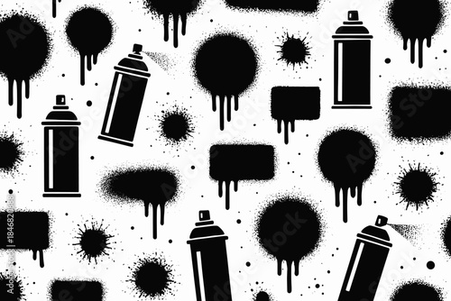 Spray paint cans and black paint splatters on a white background create a bold visual display in an urban art setting