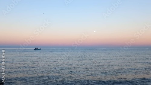 fishing boat at sunset, moon over the sea, supermoon view