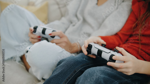 Bild auf Leinwand Friends playing video games together on a couch in a cozy living room during a r