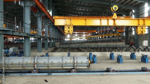 Large industrial precast concrete pile manufacturing facility with overhead crane system