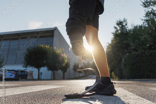 Foto Confident stride walk of a man wearing an artificial leg, an orthopedic prosthesis, going across the street on a zebra crossing