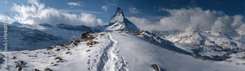 Wallpaper Mural A trail winds through snow leading up to a tall mountain peak. Clouds hover above the summit. The scene shows a cold environment far from cities and crowds Torontodigital.ca