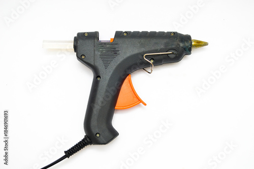 Black electric hot glue gun with an orange trigger and transparent glue stick, isolated on a pure white background. Concept for DIY, crafting, repair tool, industrial adhesive, and hobby equipment.