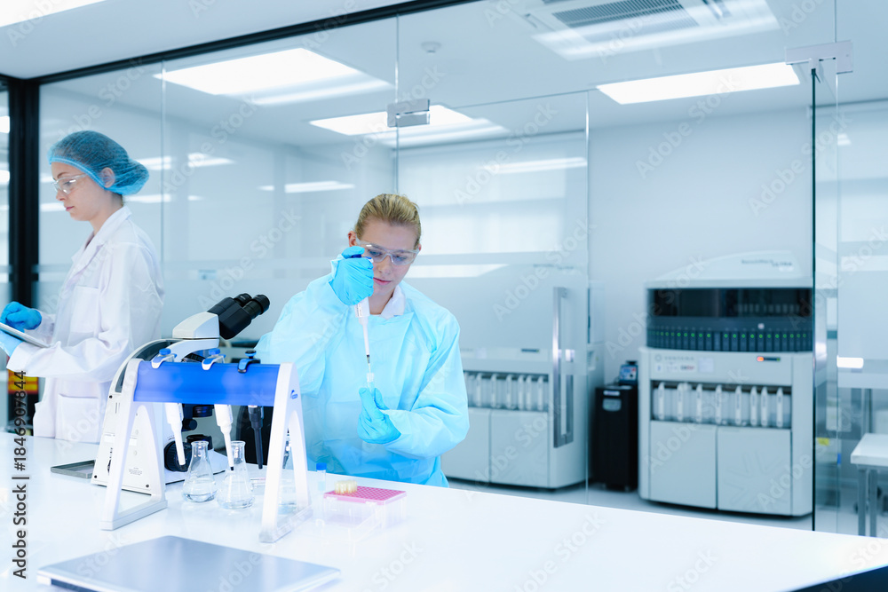 Naklejka premium A pharmaceutical Quality Control QC team ensures GxP compliance. Two scientists review an electronic batch record on a tablet while a third performs a required analytical test.