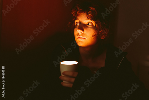 young woman with a candle in a dark room