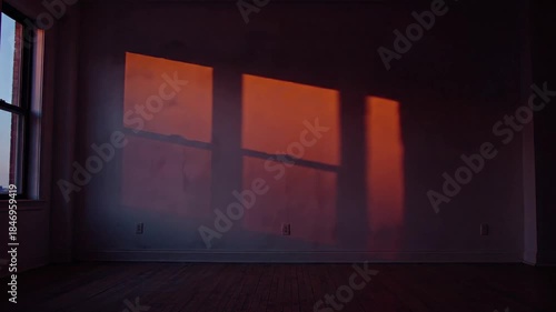 Empty Room Illuminated by Golden Hour Sunlight Streaming Through a Window Casting Geometric Shadows on Textured Walls and Wooden Floor