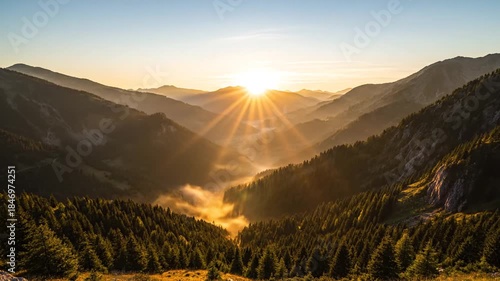 Majestic Mountain Valley At Sunrise With Dramatic Clouds And Fog Layers Illuminating Dark Pine Forest Below In Golden Hour Light