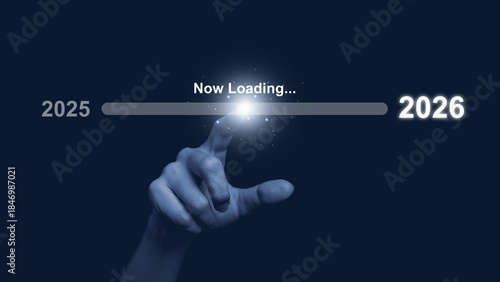 Human hand touch progress bar labeled now loading from 2025 to 2026 on dark background, symbolizing future transition, digital progress, new year change, innovation, technology advancement concept.