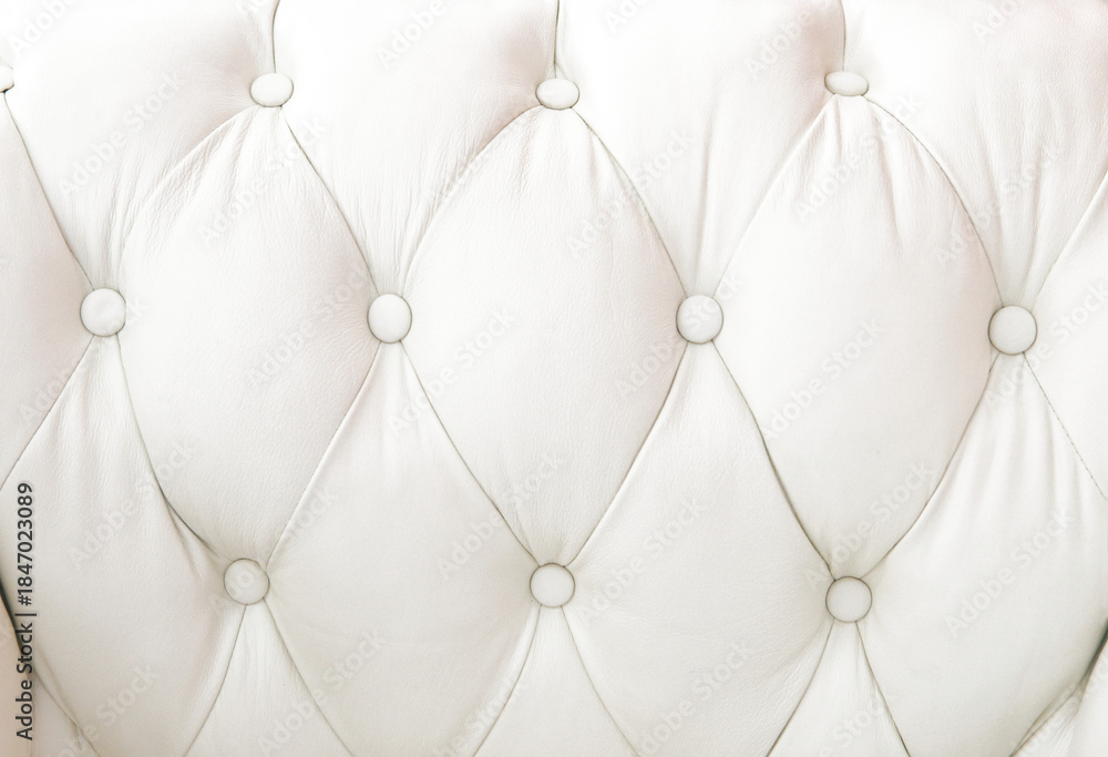 Obraz premium Tapizado en cuero claro con diseño capitoné en rombos y botones redondos, formando superficie acolchada.