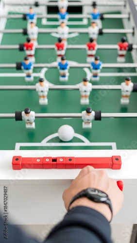 Friends gather around a foosball table, eagerly taking turns as they compete. Laughter fills the air as colorful players clash in a spirited game, creating unforgettable memories