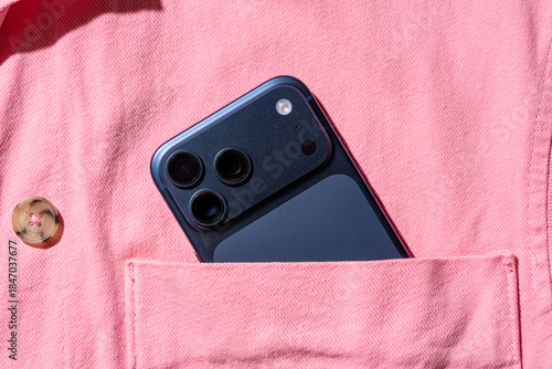 Smartphone in a pink shirt pocket with a button
