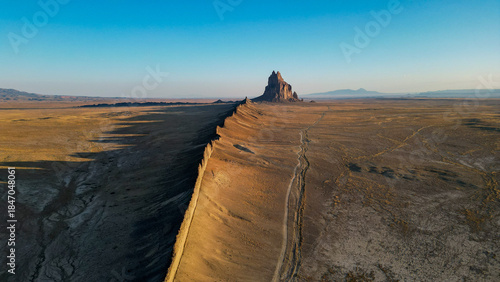 A large rock sits in the middle of a vast, empty desert
