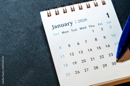 Close-up view of a calendar page showing January 2026, highlighting the date 30. A blue pen rests nearby, indicating planning and organization for the month.