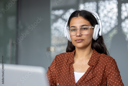 Bilde på lerret Young woman wearing headphones and glasses concentrating while learning or worki