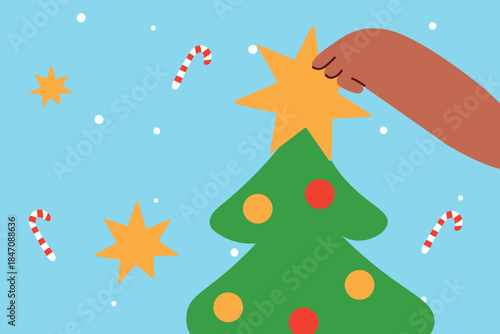 A hand hangs a star on a Christmas tree with balls