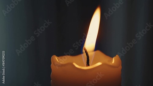 Glowing Flame of Remembrance: A close-up view of a flickering candle, its flame dancing against a blurred backdrop, evokes a sense of introspection and reverence.