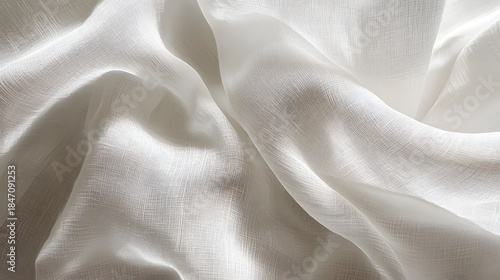 Crumpled white muslin fabric background showing soft organic folds, shadows, and detailed cotton gauze texture.