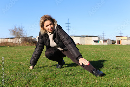 Woman doing morning exercises on an outdoor sports ground