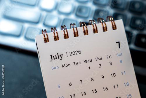 A close-up view of a desk calendar displaying July 2026, highlighting dates. Ideal for planning, scheduling, or time management discussions in an office setting.