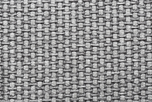 Textured gray fabric background showcasing intricate woven patterns, highlighting the craftsmanship and material quality, ideal for design and textile applications with copy space