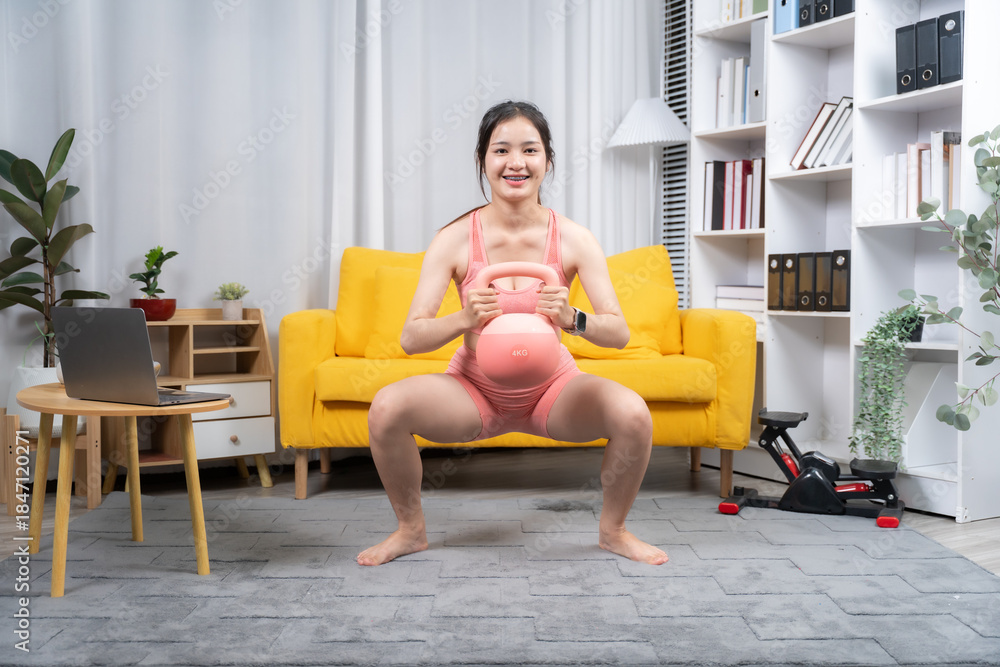 Obraz premium Prenatal Workout: A pregnant woman practices a controlled squat with a kettlebell in a cozy and well-lit interior, embracing her strength and health during her pregnancy journey.