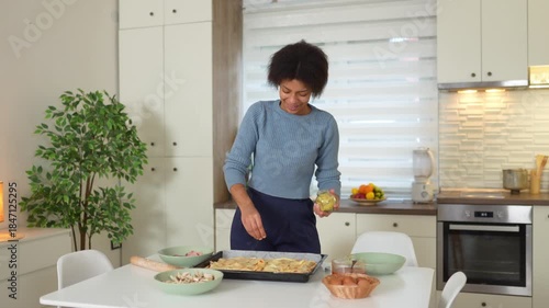 African American woman sprinkling spices onto homemade food