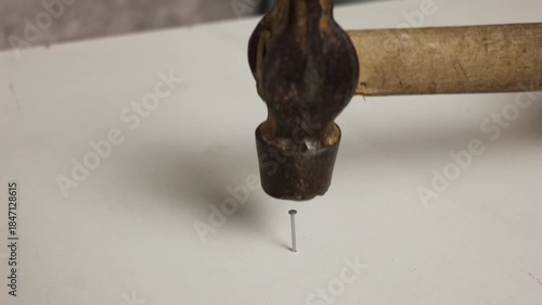 A hammer hammering a nail close-up
