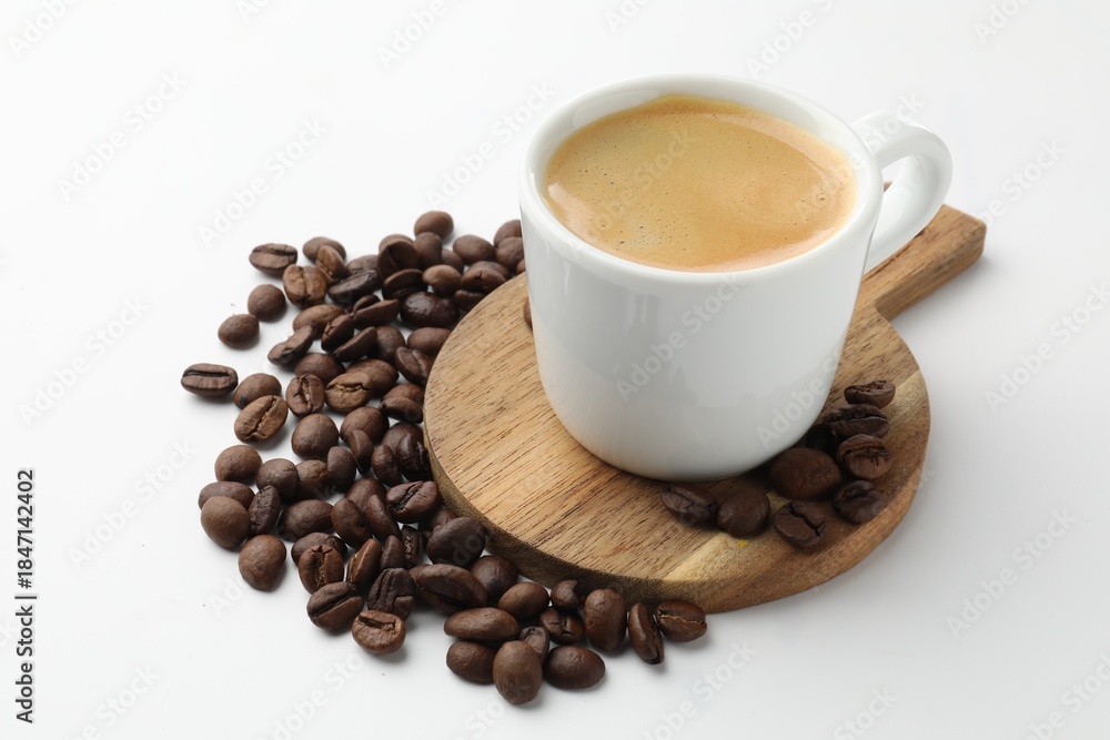 Obraz premium Cup of aromatic coffee and roasted beans on white background, closeup