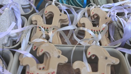 Ceramic Christmas ornaments displayed at a European holiday market, glowing in warm winter lights and creating a cozy festive atmosphere.