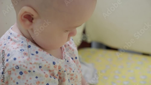 Baby is sitting and chewing toy on the floor home setting. Exploring textures while soothing sore gums. Sensory discovery at home. teething relief and baby care concept. early childhood curiosity