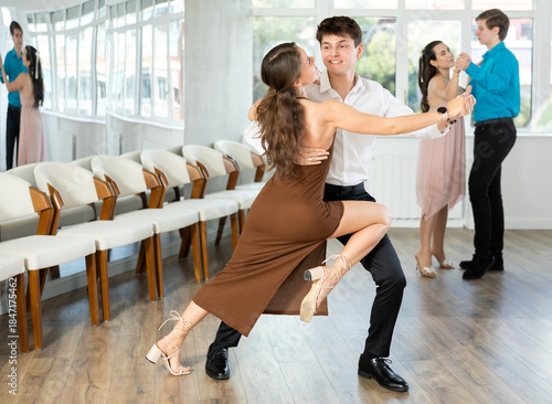 Fotografi Guy and girl in couple spins to rhythm of tango during lesson for novice students