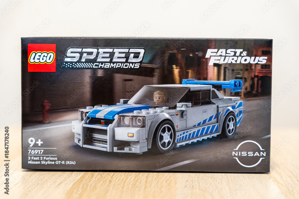 Naklejka premium Warsaw, Poland - Dec 16, 2025: A LEGO box displaying the Speed Champions Nissan Skyline GT-R from Fast & Furious, aimed at children aged 9+, set against a soft background.