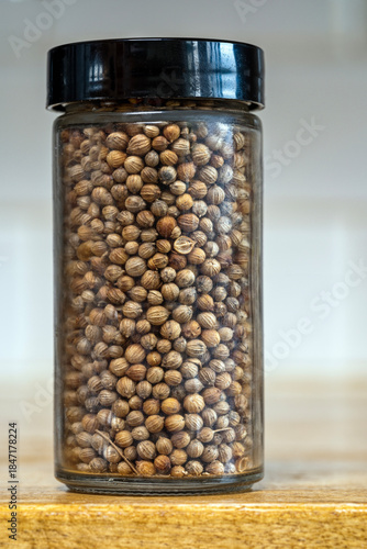 Detail of a glass jar of coriander seeds